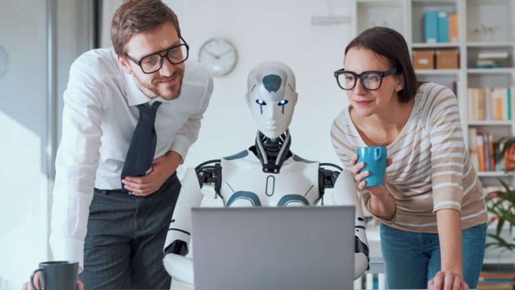 Dos profesionales observan junto a un robot humanoide una pantalla, simbolizando la relación entre la IA y el futuro del trabajo.