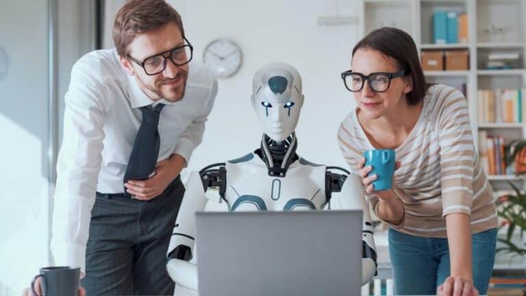 Dos profesionales observan junto a un robot humanoide una pantalla, simbolizando la relación entre la IA y el futuro del trabajo.