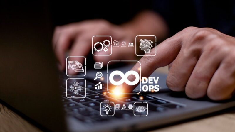 Manos tecleando sobre un portátil con ilustraciones digitales flotantes representando DevOps, inteligencia artificial y flujos de trabajo automatizados