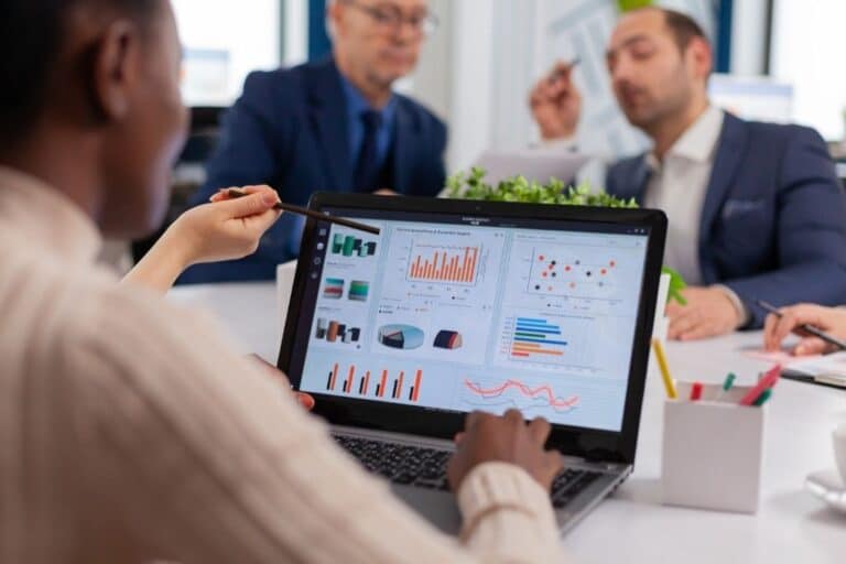 Qué es un especialista en Business Intelligence: profesional revisando en portátil cuadros de mando con KPIs, gráficos de barras y líneas